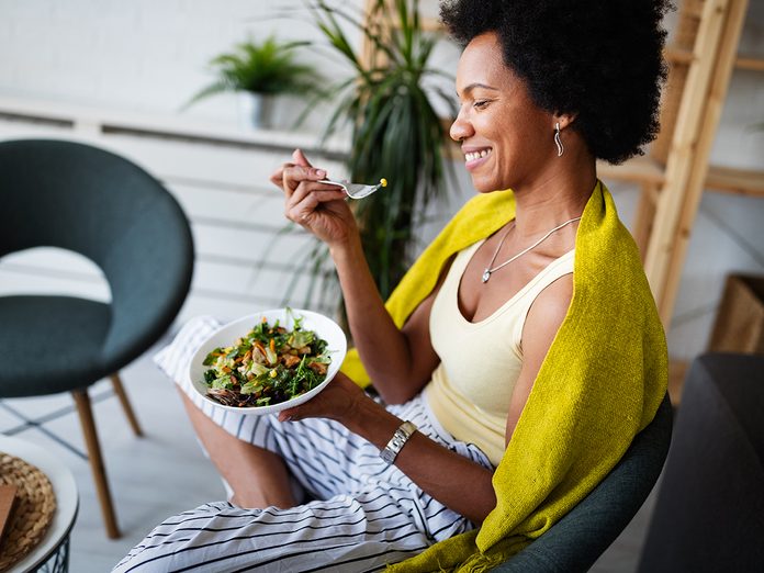 woman eating vegetable salad at home