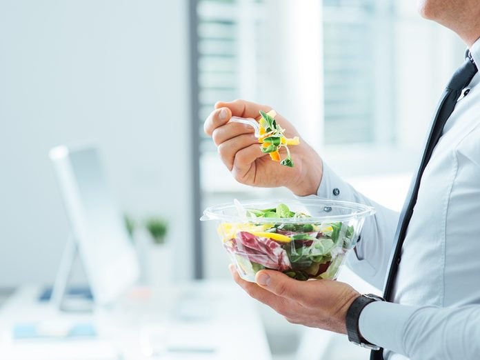 Businessman having a vegetables salad for lunch, healthy eating and lifestyle concept, unrecognizable person