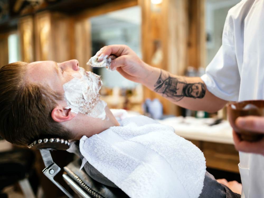 Man being shaved at an old-school barbershop