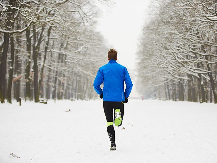 Man running on trail during winter