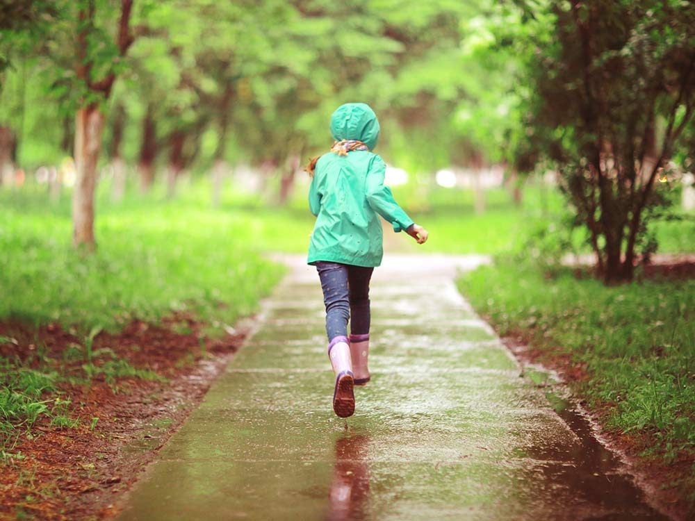 Little girl running in spring rain