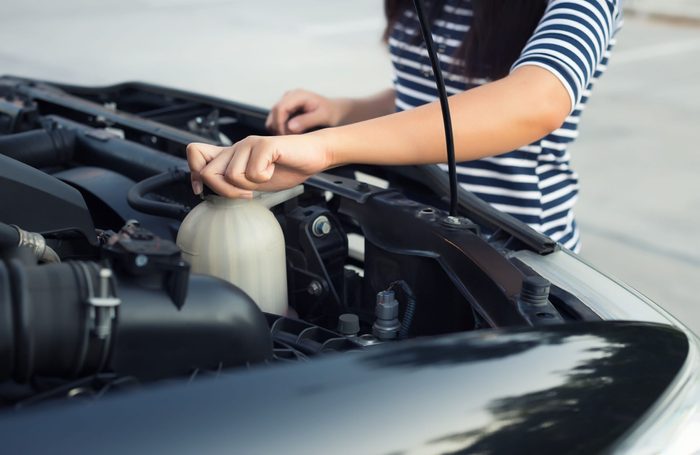 Woman checking engine coolant