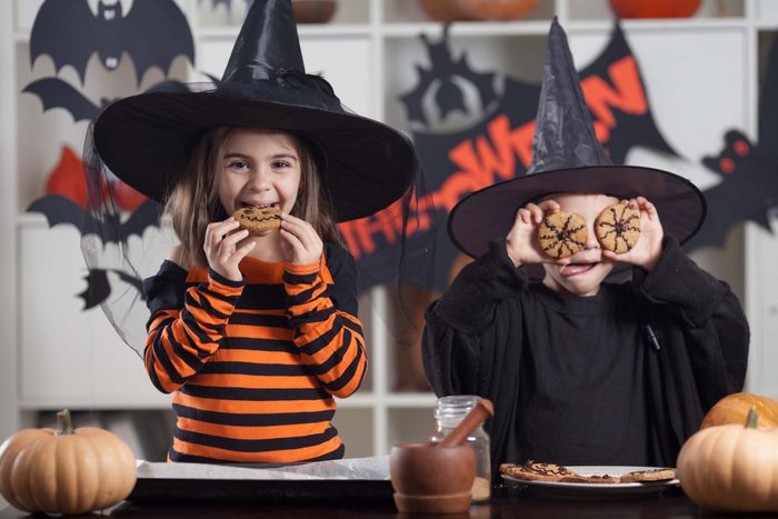 Two children eating cookies at Halloween party