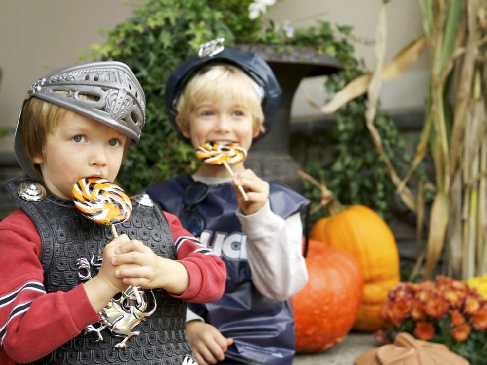 Brothers eating lollipops on Halloween