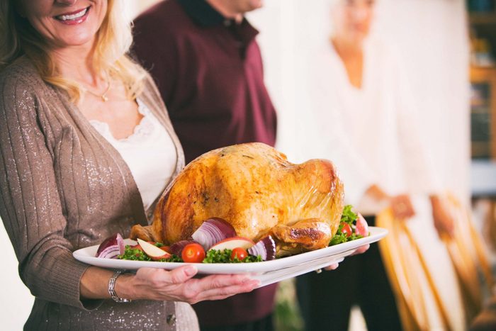 Woman carrying turkey for Thanksgiving dinner