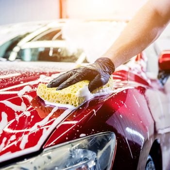 How to clean a car - man washing red car
