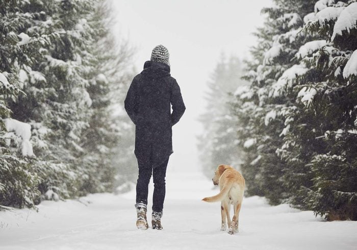 Woman walking dog outdoors in winter