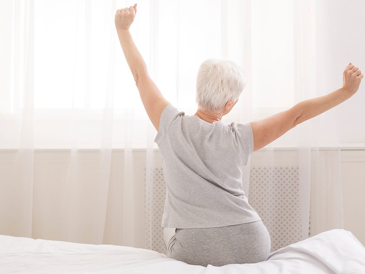Stiff neck relief - senior woman doing stretches at morning