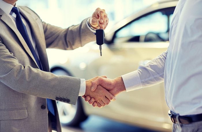 Car salesman giving keys to customer