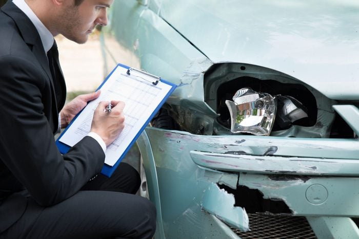 Insurance agent assessing damage on car