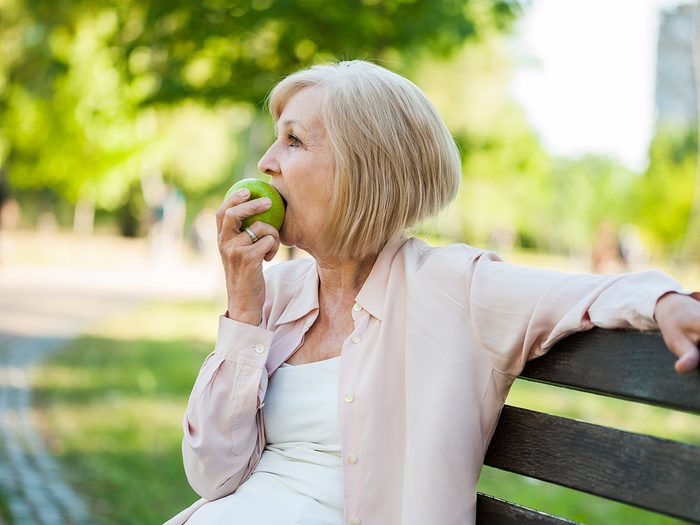 Apple benefits - mature woman eating apple