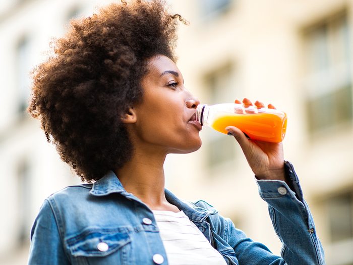 Сколько воды нужно пить - женщина пьет апельсиновый сок