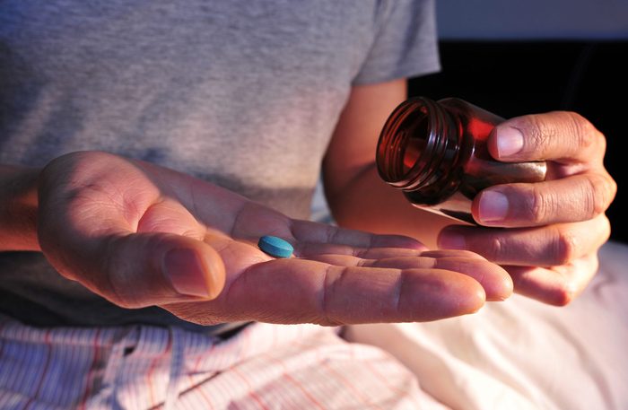 Man with Viagra pill in bed