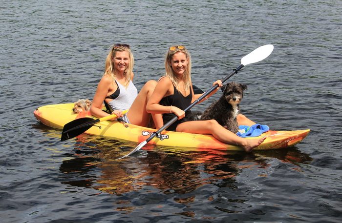 Two women on kayak with two dogs