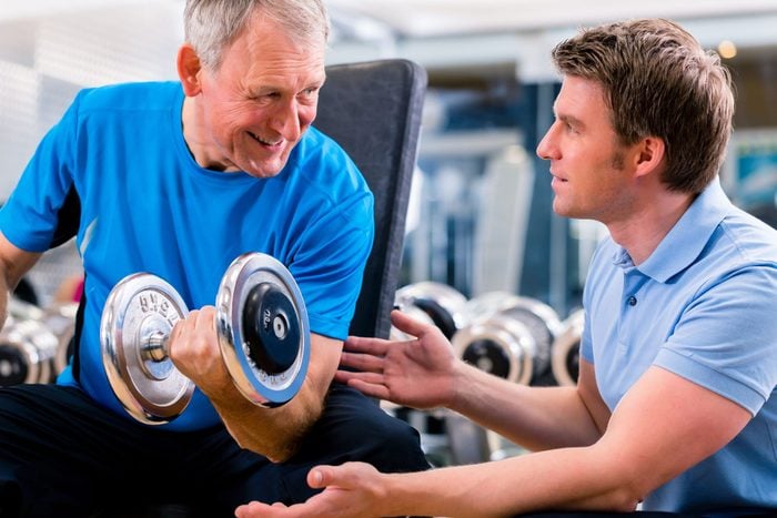 Old man exercising with personal trainer