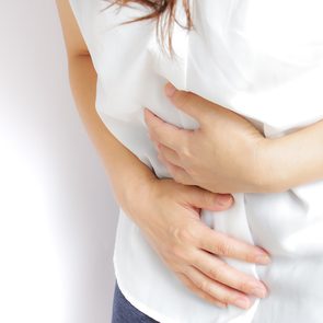 Fatty liver symptoms - woman with stomach discomfort