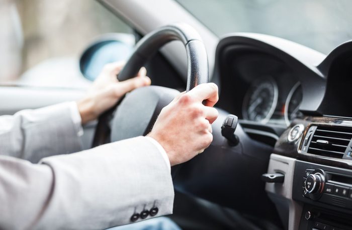 Close-up of hands on steering wheel