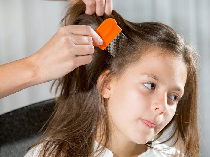 Mother checking child's hair for head lice