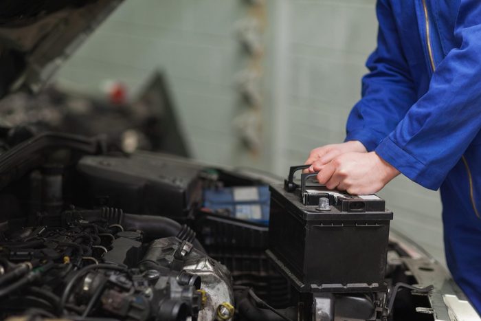 car repair tips - Mechanic checking car battery