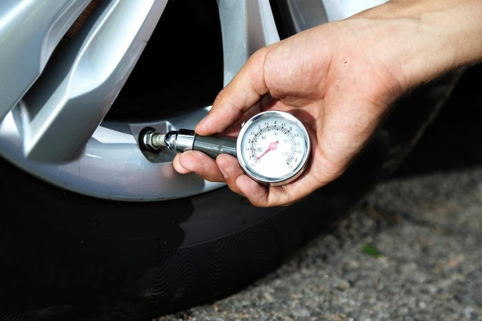 car repair tips - Man checking air pressure of car tire