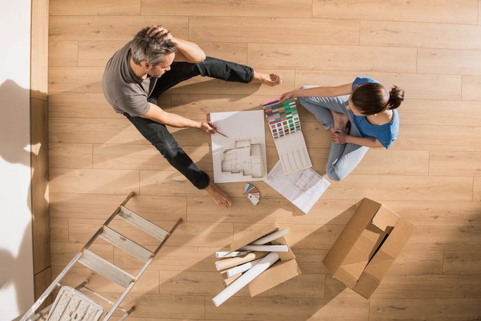 Young couple planning on living room floor