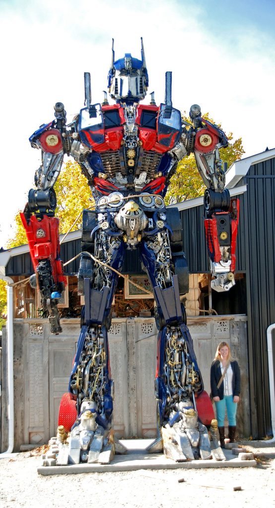 Woman standing next to Transformers replica
