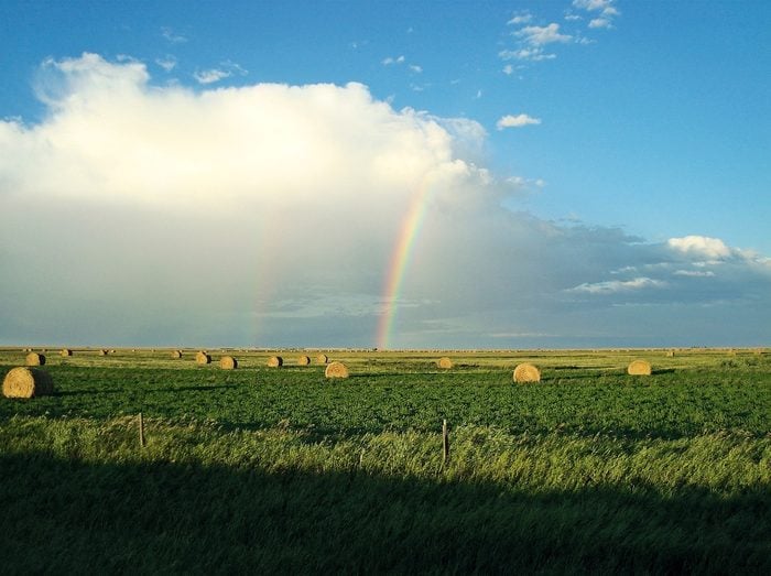 Rainbow over hay farm in Alberta