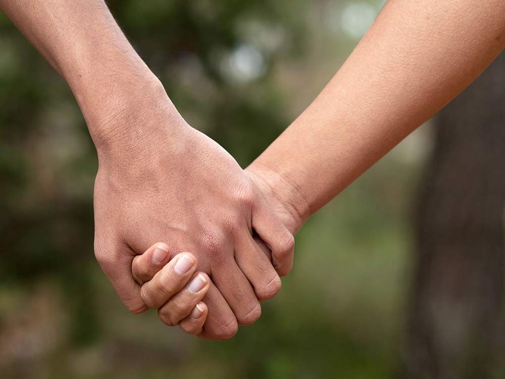 Two teenagers holding hands