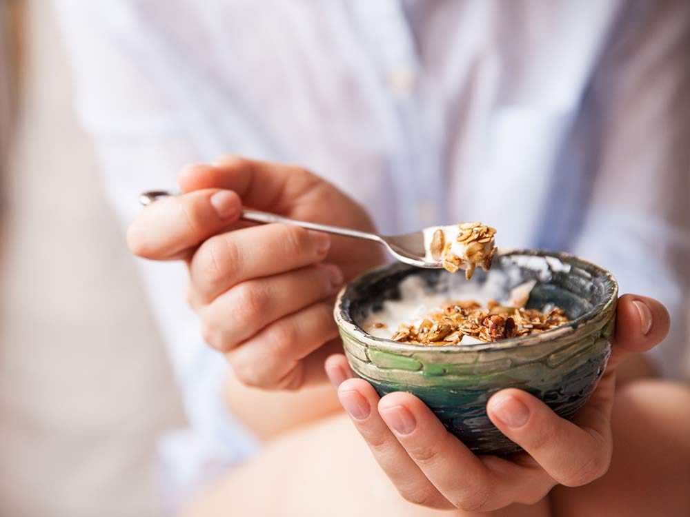Woman eating small cereal bowl