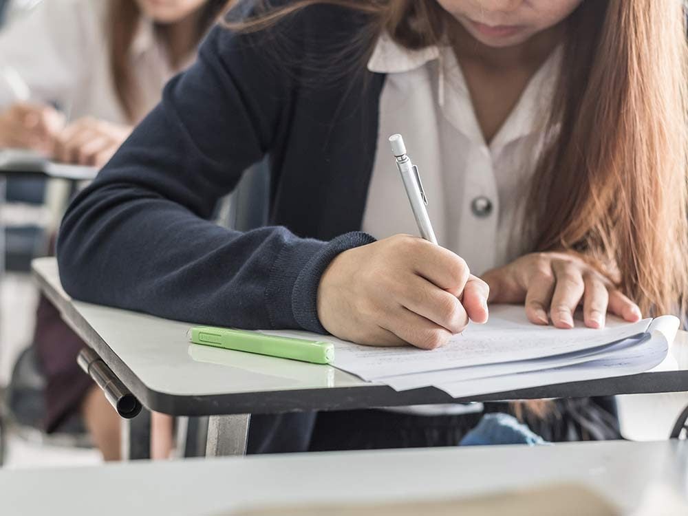 Student writing her high school exam
