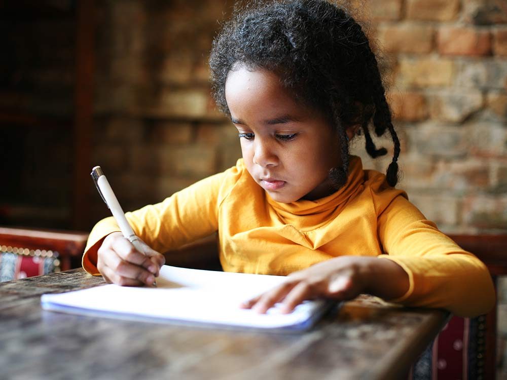 Child writing in her notebook