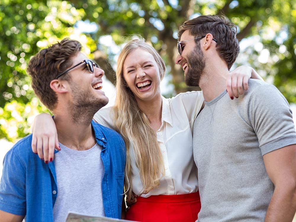 Three hip young friends laughing outside