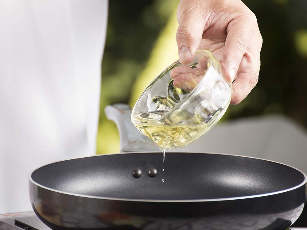 Man pouring oil directly into pan