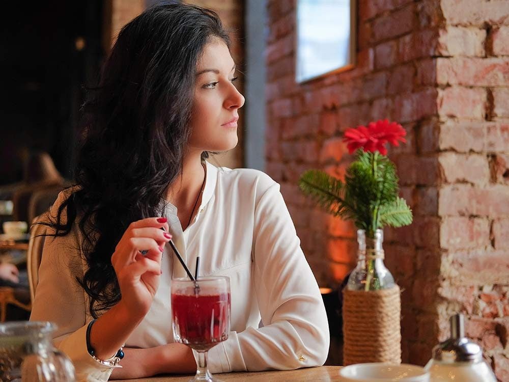 Woman drinking mulled wine alone at restaurant