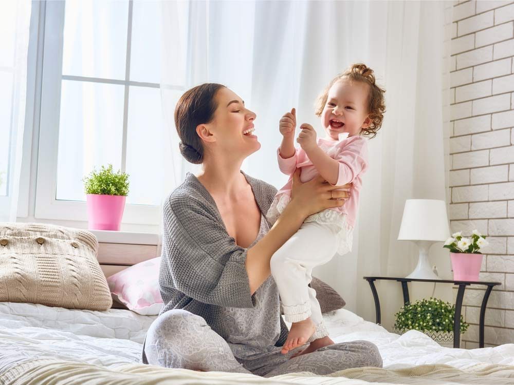 Mother and young daughter laughing and playing