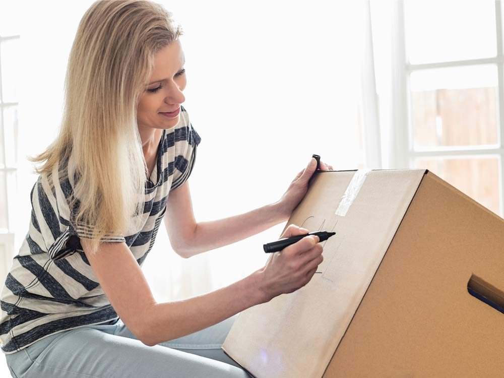 Woman labelling box on moving day