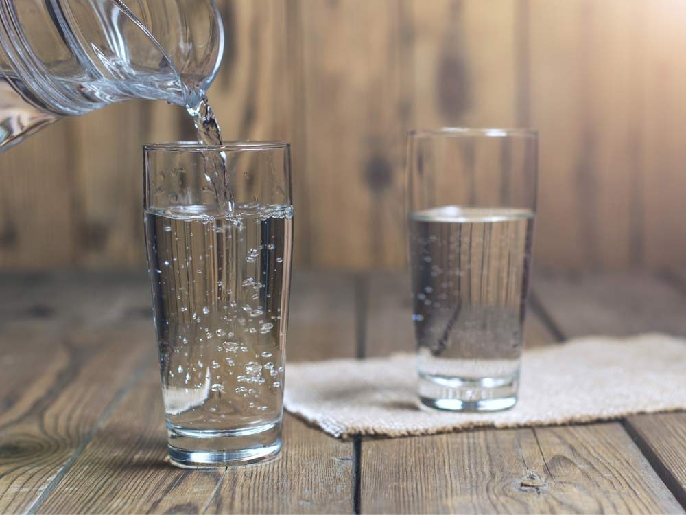 Water being poured into clear glasses