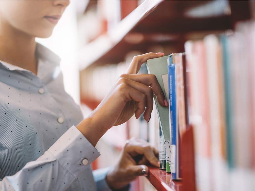 Woman looking through books at public library