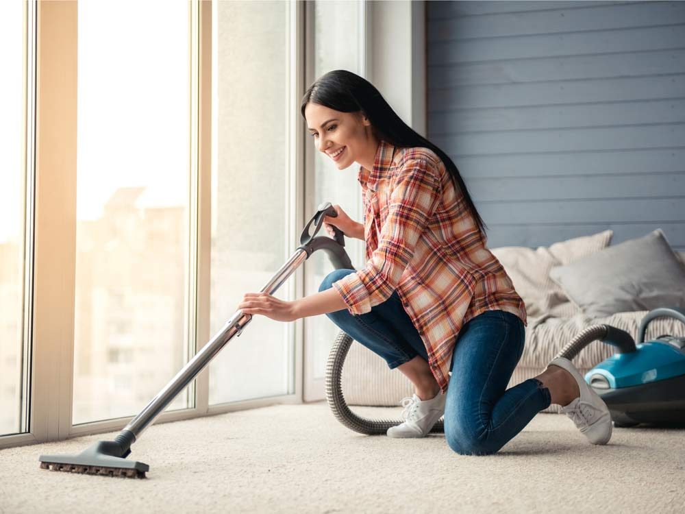 Woman vacuuming her living room carpet