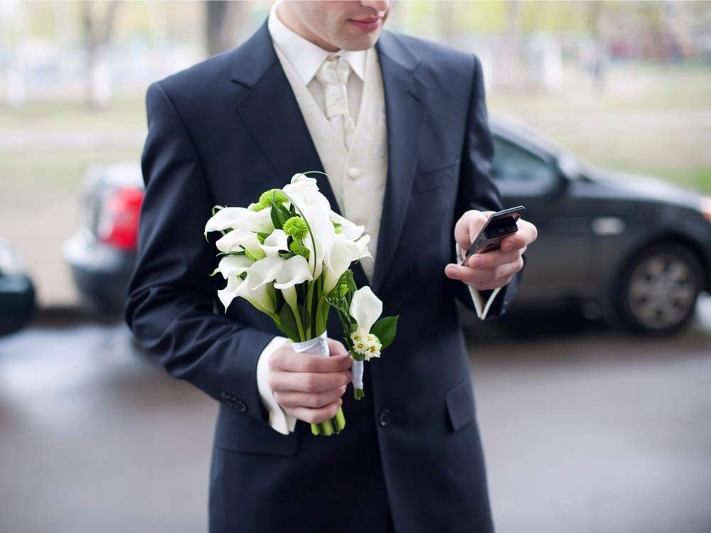 Groom using phone during ceremony