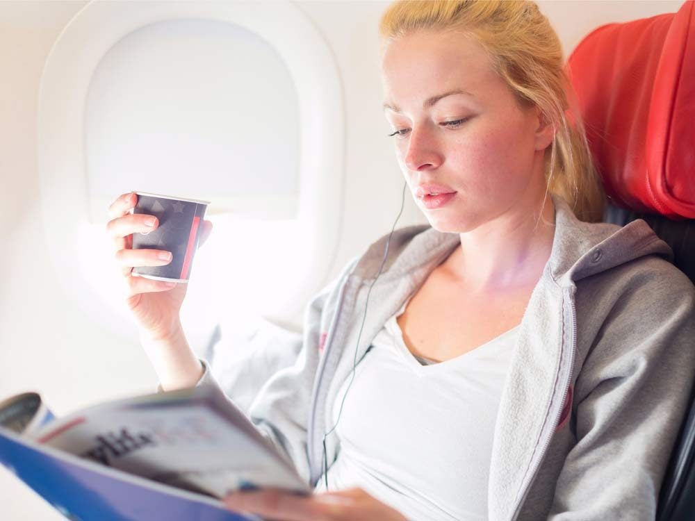 Woman reading a magazine on flight