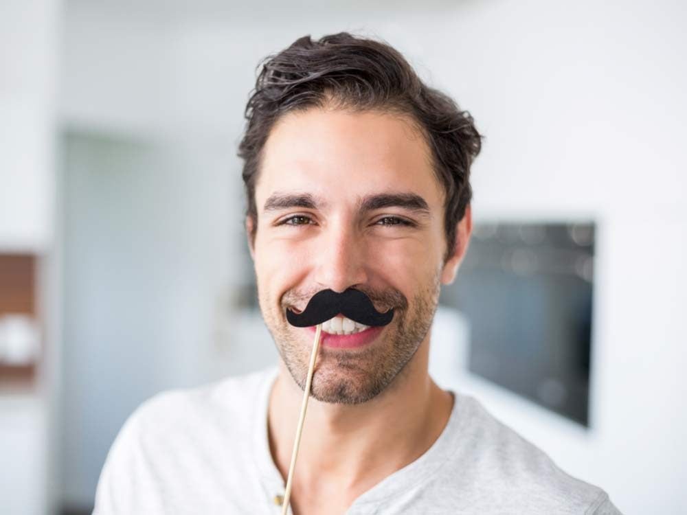 Man wearing fake moustache for Movember