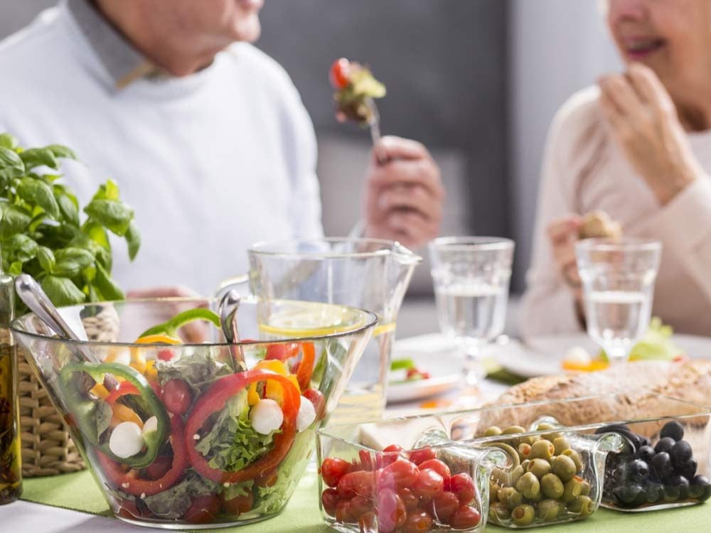 Elderly couple eating healthy salad meal