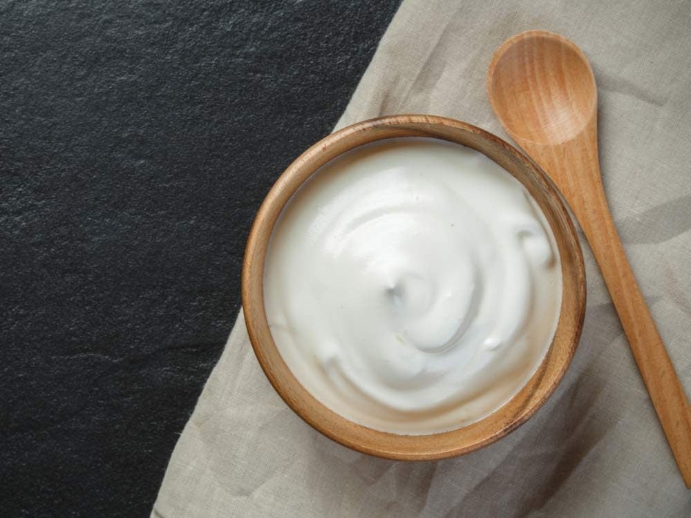 Sour cream in wooden bowl