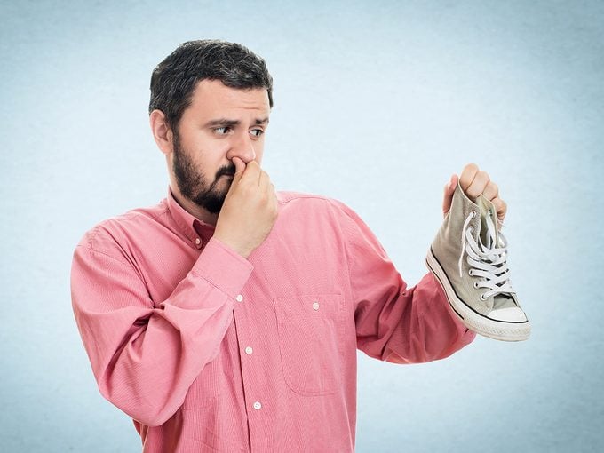 DIY smelly feet solutions - man holding smelly shoe