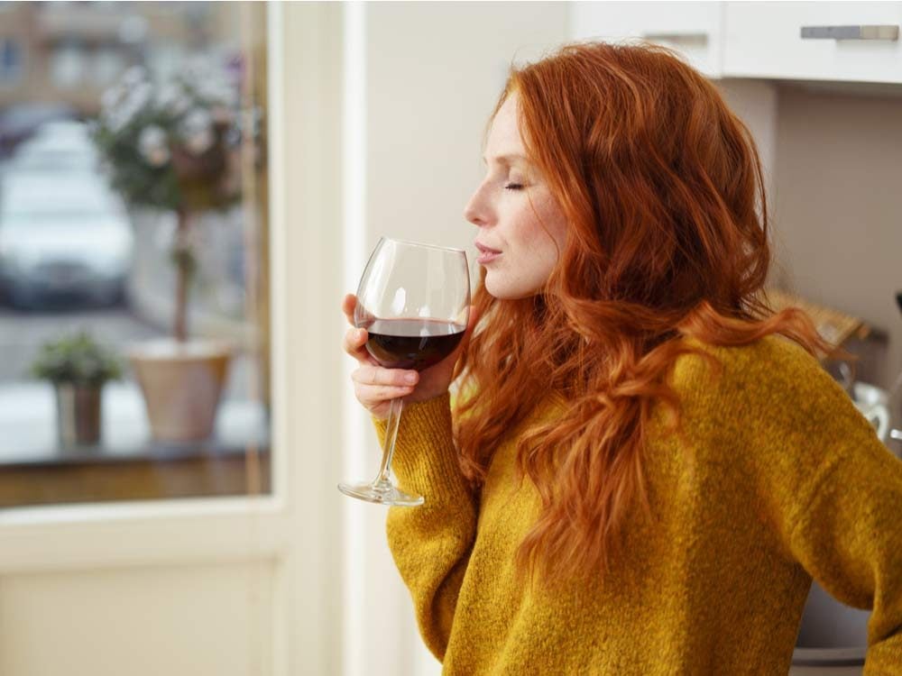 Red haired woman drinking wine