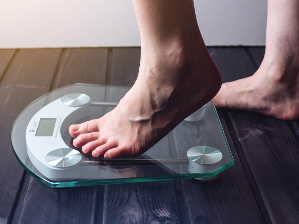 Woman stepping on weight scale