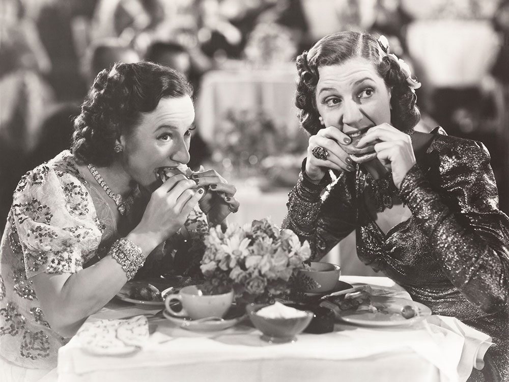 Black and white period photo of two women eating