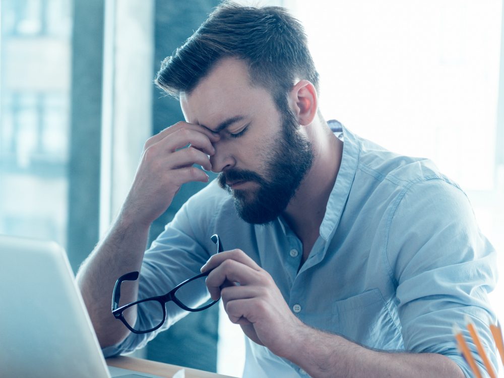 Man suffering from lack of sleep at work