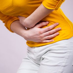 IBS triggers - woman doubled over with cramps